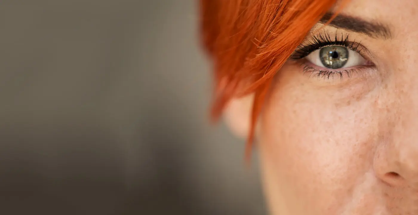 Close-up van een oog van een vrouw met rood haar
